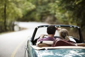 Couple taking a road trip in vintage convertible.