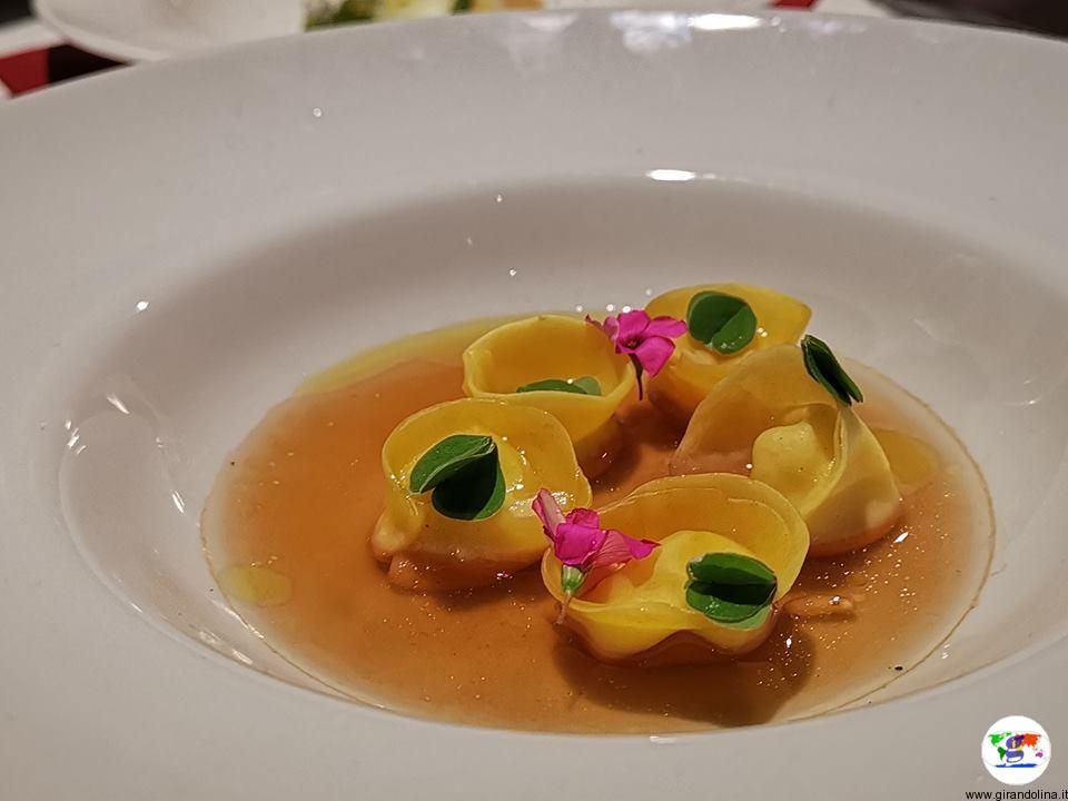 Tasting Montecatini, tortelli di pecorino toscano,brodo di pigne verdi e pinoli ,suoi aghi caramellati, miele di fieno e acetosa di campo proposti dal Ristorante Atman